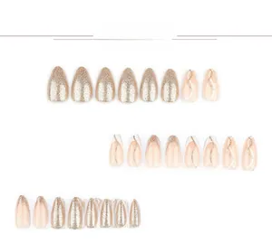 Detailed view of champagne gold glitter press-on nails with almond shape and wavy lines