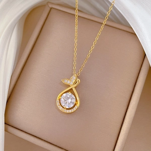 Detail of fishtail drop pendant with sparkling crystals on a golden titanium necklace