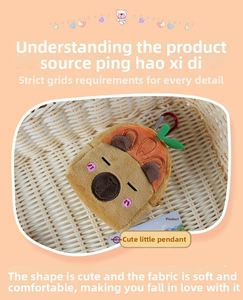 Detail of Capybara plush keychain with orange fruit hat and red metal carabiner clip