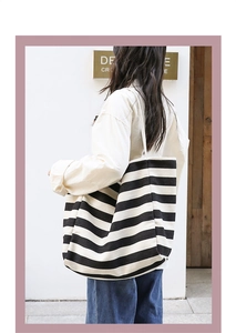 Outdoor shot of a striped canvas tote bag showing its large capacity and thick texture