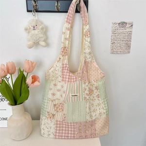 Detail der floralen Patchwork-Einkaufstasche mit Markenlabel an einer Wand