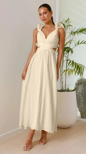 Dettaglio dell'elegante abito lungo con scollo a V, tagli laterali e fiori sulle spalline
