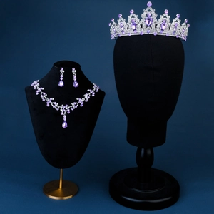 Detailed bridal jewelry set with purple crystals and silver tiara on a black bust