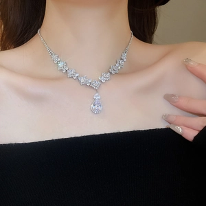 Close-up of a silver necklace with sparkling cubic zirconia and a teardrop pendant