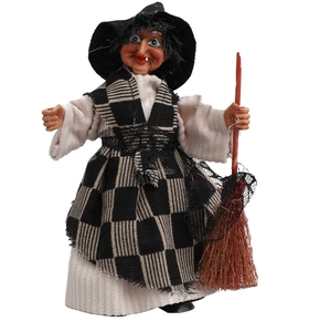 Detailed view of Halloween witch doll with black pointed hat and broomstick decor