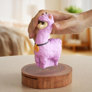 Detail of a purple alpaca candle with sunglasses and a gold letter pendant held in hand