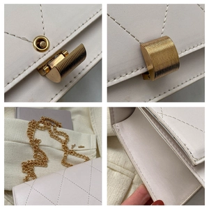 Detailed macro view of the gold-toned striped lock and quilted stitching on the ivory bag