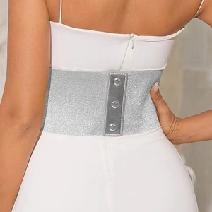 Back view of silver elastic wide waist belt on a white dress with metal buckle closure
