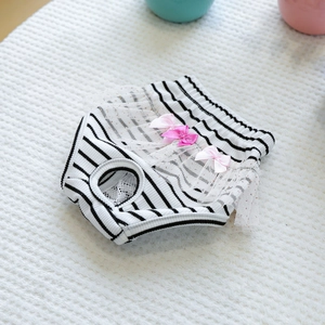 Detail of dog sanitary pants with black stripes, pink bows, and delicate lace trim