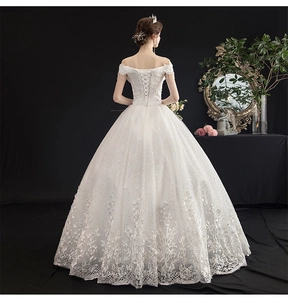 Detailed back view of a white off-shoulder bridal gown featuring lace corset lacing and sequins