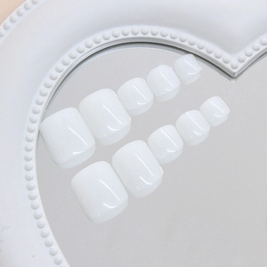 Faux ongles d'orteils blancs brillants carrés présentés dans un plateau en cœur
