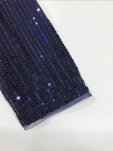 Primer plano de lentejuelas azul oscuro y textura de malla en la manga del vestido
