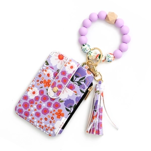 Detail of floral zipper card holder with purple silicone bead wristlet and tassel charm