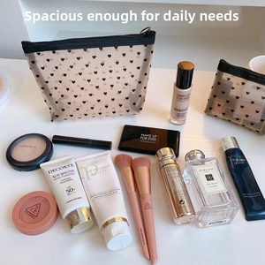 Flat lay of mesh makeup bags with black heart prints and secure zipper closures