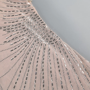 Detailed view of silver rhinestones and crystal beadwork on nude mesh fabric dress