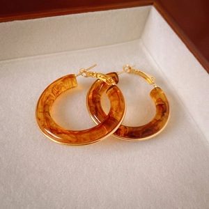 Vintage gold plated hollow hoop earrings with amber resin texture in a gift box
