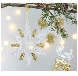 Close-up of clear acrylic snowflake ornaments with gold glitter and ribbons