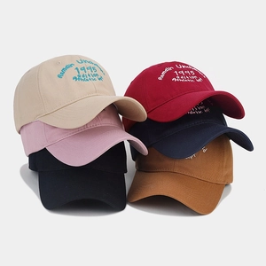 Detail view of six classic baseball caps in assorted colors with 1995 embroidery