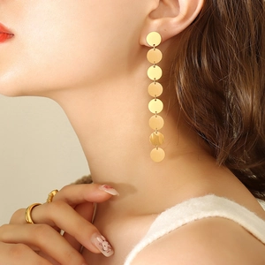 Elegant gold multi-disc drop earrings with brushed finish on a female model