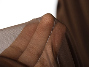 Close-up of brown elastic mesh fabric showing transparency and fine texture details