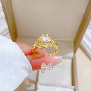 Close-up of gold wrap ring featuring a round center stone and sparkling pavé accents