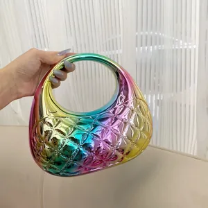 Close-up of quilted iridescent acrylic clutch with polished gradient surface and handle