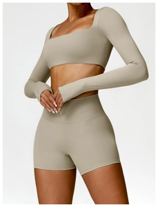 Λεπτομέρεια από crop top με μακριά μανίκια, τρύπες για αντίχειρες και σορτς γυμναστικής