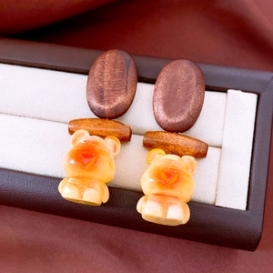 Macro detail of vintage wooden bear earrings on elegant leather jewelry box lining
