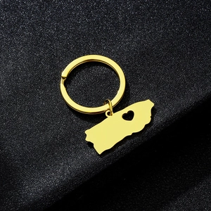 Macro shot of gold Puerto Rico map keychain with heart cutout on black leather background