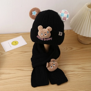 Close-up of black knitted winter hat and scarf set with cute plush bear and mini baby embroidery