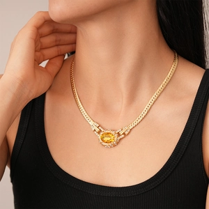 Vintage gold necklace with a large yellow oval gemstone and diamond accents on flat chain