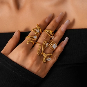Close-up of gold-plated geometric rings with cubic zirconia on model hands