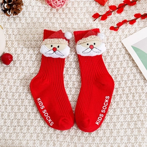 Détail de chaussettes de Noël rouges pour bébé avec décor Père Noël 3D sur tricot