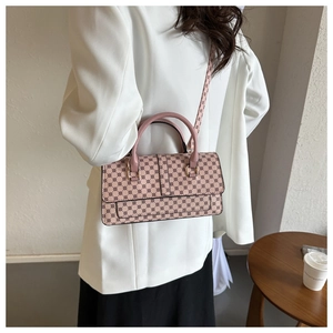 Pink geometric pattern handbag with double handles and gold hardware on white blazer