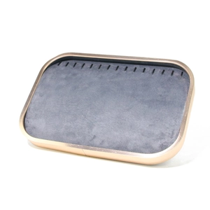 Detail of rose gold metal jewelry tray with grey microfiber lining and hooks