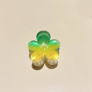 Detailed view of green and yellow gradient frangipani hair claw clip with subtle glitter finish