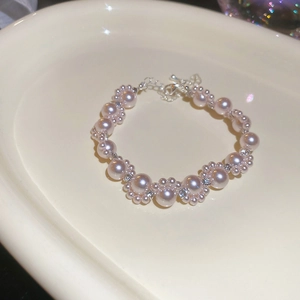 Detailed view of pink pearl bracelet with rhinestones on cream ceramic tray
