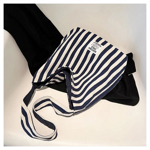Detail of blue and white striped canvas tote bag showing premium fabric texture and strap