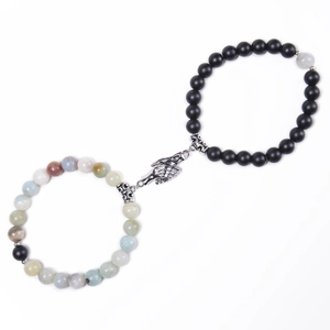 Detail of magnetic couple bracelets featuring matte black beads and colorful stones