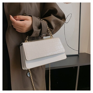 Détail du sac à bandoulière blanc à motif crocodile et chaîne dorée élégante