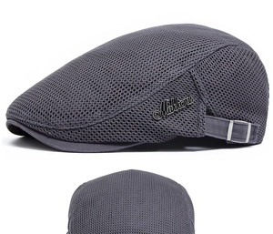 Detailed close-up of dark grey mesh fabric and Mabberas metal logo on the newsboy cap