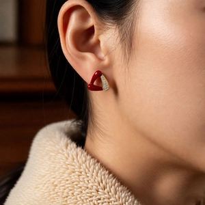 Détail de boucle d'oreille triangle en émail rouge et zircons plaqué or 18 carats