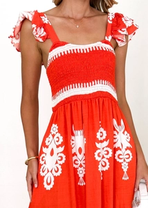 Détail de la robe de plage orange à motif floral avec bustier smocké et volants