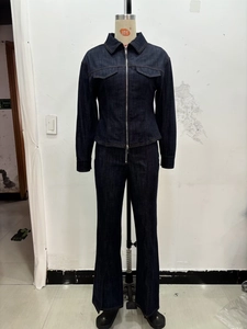 Détail d'un ensemble deux pièces en denim bleu foncé avec veste ajustée et jean évasé