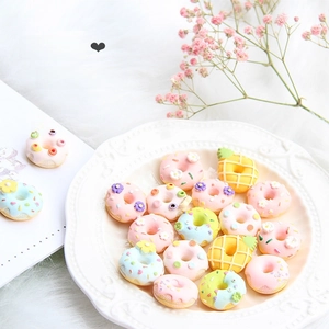Makroaufnahme von Morandi Harz-Donut Miniaturen mit Streuseln auf weißem Teller