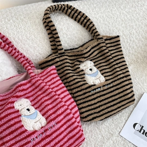 Detail of cute striped plush tote bags with cartoon dog embroidery and soft texture