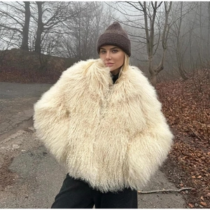 Gros plan de la texture en fausse fourrure bouclée d'une veste d'hiver crème