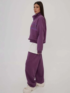 Purple two-piece loungewear set with quarter-zip sweatshirt and wide-leg jogger pants