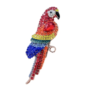 Vintage parrot brooch featuring golden metal and colorful rainbow rhinestones on white background