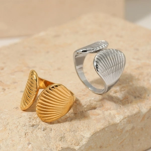 Minimalist stainless steel open ring with shell texture on natural stone pedestal